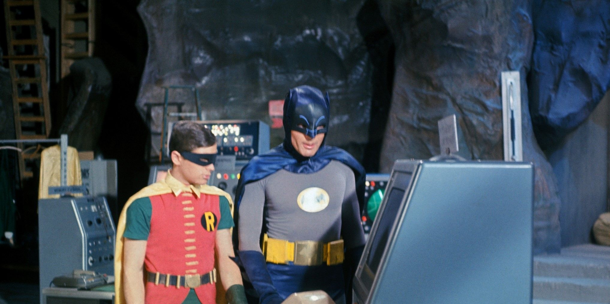 Adam West nei panni di Batman con Burt Ward nei panni di Robin nella Batcaverna, utilizzando uno dei tanti computer nella grotta