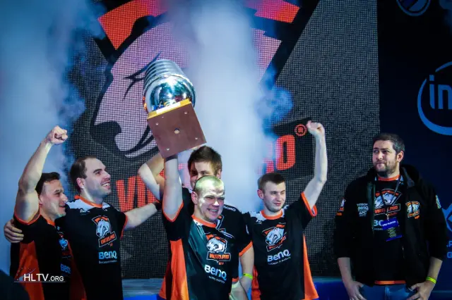 NEO di Virtus.pro solleva il trofeo EMS One Katowice sul palco con i suoi compagni di squadra che alzano le mani in aria.